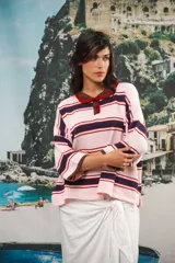 Remera rosa con rayas horizontales azul marino y bordó, cuello tipo polo marrón con botones y mangas cortas amplias.