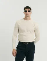 Sweater de punto con textura tipo waffle, color negro, de corte clásico con cuello redondo y mangas largas.