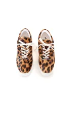 Championes estilo zapatillas urbanas con capellada de cuero pelo con estampado animal print tipo leopardo, cordones blancos y suela de goma blanca.