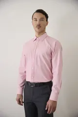 Camisa de vestir blanca de manga larga, con cuello clásico y cierre frontal de botones. Presenta un corte entallado que se adapta a la silueta.