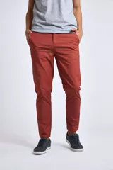 Pantalón tipo chino de gabardina en color terracota, con corte regular, bolsillos laterales y cierre frontal con botón y cremallera.