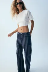 Jeans de tiro medio y corte recto, con diseño de rayas verticales en tonos de azul. Cuenta con trabillas, cinco bolsillos y cierre frontal con cremallera y botón metálico.