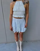 Minifalda bordó con diseño de tres niveles de volados y cintura elástica.