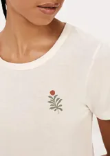 Pijama compuesto por una remera de algodón color crema con estampa pequeña en el pecho y un short de tela liviana color beige con estampado de cuadrícula fina.