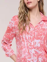 Blusa celeste con estampado efecto pincelada blanca, de corte semi holgado, escote en V con cuello solapa y media abotonadura frontal con botones nacarados. Presenta finas alforzas verticales en la pechera y mangas 3/4 con puños elastizados.