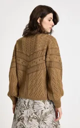 Sweater de punto color camel con diseño calado geométrico, cuello redondo y mangas largas con volumen suave. Presenta puños y dobladillo acanalados.