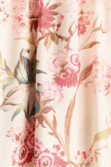 Vestido largo de mezcla de viscosa en color beige con estampado floreado. Presenta un escote en V pronunciado, botonadura frontal con botones forrados, y mangas largas abullonadas con puños ajustados. Cuenta con costuras fruncidas bajo el busto y en la cintura, dando paso a una falda de corte fluido y leve vuelo.