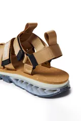 Sandalias tipo trekking color beige, con tiras de nylon ajustables y suela técnica con diseño ergonómico y detalles multicolor en la base.