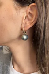 Caravanas tipo argolla doradas con dije de perla desmontable. Diseño delicado y minimalista, apto para perforación.