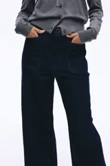 Pantalón de jean color azul marino, de tiro alto y corte wide leg, con amplios bolsillos frontales de parche y presillas para cinturón.