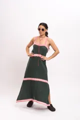 Vestido largo de punto tipo solera en color verde oscuro, con tirantes anchos y detalles de rayas horizontales en color rosado claro en el escote, la cintura, los cortes de la falda y el ruedo.