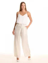 Pantalón wide leg de tela laminada metalizada color blanco, con pretina elástica y lazo de ajuste en la cintura. Cuenta con bolsillos laterales.