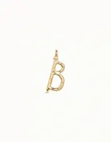 Dije con forma de letra B, con acabado en baño de oro de 18k y diseño de líneas orgánicas.