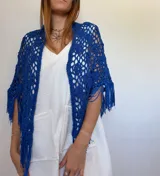 Chal azul tejido a crochet con diseño calado y flecos.