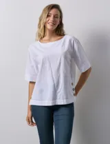 Blusa blanca de algodón, manga corta amplia, con escote redondo y detalle de botones en los tajos laterales del ruedo.