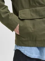 Campera utility color verde militar, de manga larga con cuello camisero de pana. Diseño liviano y resistente con cierre de botones, dos bolsillos frontales con solapa y dos bolsillos laterales. Interior forrado en poliéster reciclado y acabado repelente al agua.