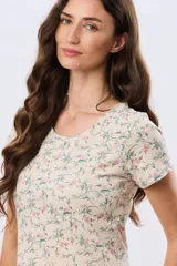 Remera de manga corta con cuello redondo, confeccionada en algodón con estampa de diseño floral en tonos rosados y verdes sobre base beige.