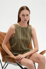 Musculosa verde militar con diseño de rayas verticales blancas y finas, cuello redondo y corte holgado.