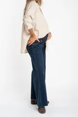Jean de corte flare wide leg con tiro medio y ruedo desflecado. Confeccionado en denim de algodón, presenta un tono azul oscuro uniforme con costuras en contraste.
