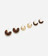Kit de tres pares de caravanas tipo argolla de diferentes tamaños y grosores, combinando metal dorado y resina con efecto marmolado en tonos marrones. Incluye pares con acabado liso y con textura.