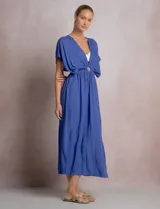 Vestido midi túnica color azul de la marca Elan, de corte holgado con escote en V profundo y mangas mariposa. Cuenta con una argolla central forrada que une el fruncido del busto y genera sutiles aberturas cut-out en la cintura. Presenta cintura elastizada y falda fluida con tajo lateral.
