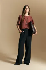 Pantalón de vestir negro de corte ancho y silueta recta, con diseño de tiro medio y bolsillos laterales. Presenta una caída fluida y estructurada, ideal para un look formal o de oficina.