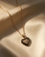 Collar de acero con baño de oro, compuesto por una cadena fina y un dije en forma de corazón que combina cerámica negra y circonias brillantes.