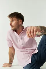 Camisa de manga corta confeccionada en una mezcla de lino y algodón, con cuello camisero, cierre frontal de botones y bolsillo en el pecho con logo bordado.