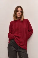 Buzo tejido color borgoña con cuello redondo y diseño de trenzas verticales.