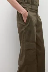 Mono de estilo utilitario color verde oliva, con cuello camisero, cierre frontal con botones, mangas cortas y bolsillos tipo cargo.