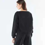 Buzo de felpa color negro con cuello redondo amplio y mangas largas. Presenta un estampado frontal en color blanco con la palabra 'LUCKY', el número '84' y tres estrellas.