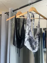 Top negro brillante con escote drapeado y espalda descubierta.