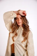 Camisa color crema con bordado de flores blancas, de manga larga abullonada y cuello clásico.