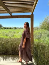 Vestido verde oliva de lino, corte suelto, con mangas abullonadas y volado en el ruedo.