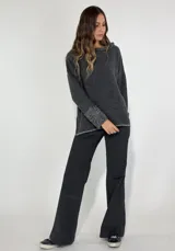 Sweater gris de manga larga con cuello redondo y puños con detalle de volados de lana rizada.