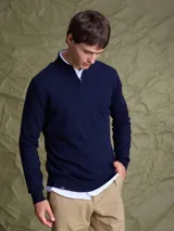 Sweater de punto color azul marino, con cuello alto y cierre frontal parcial, de manga larga y puños acanalados.