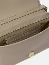 Cartera bandolera Calvin Klein de piel sintética suave en color beige, con solapa, cierre magnético, correa ajustable y monograma CK en relieve en la parte delantera.