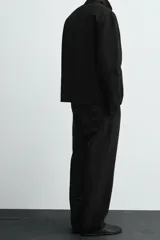 Pantalón de corte recto y ajuste relajado, confeccionado en una mezcla de algodón y lino. Presenta cintura elástica, bolsillos delanteros, bolsillo trasero de plastrón y cierre frontal con cremallera y botón.
