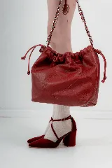 Zapato de tacón ancho color rosa viejo, de tela tipo terciopelo, con puntera fina y tiras cruzadas sobre el empeine.