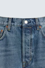 Jeans de denim de algodón, tiro medio, con corte barrel fit amplio en cadera y muslos que se estrecha hacia el tobillo. Presenta efecto lavado y cierre frontal con botones.