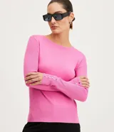 Suéter de punto color rosado, con cuello barco, mangas largas y puños con botones decorativos. El dobladillo también es acanalado.