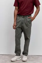 Pantalon de corte recto en color verde oliva, confeccionado en tejido de algodón con acabado ligeramente desgastado, cuenta con bolsillos laterales y cierre frontal.