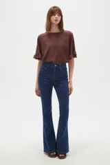 Pantalón jean de corte oxford, tiro alto, con bolsillos y diseño de pernera ajustada en muslos y acampanada desde las rodillas.