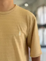Remera oversize de tejido texturizado en color verde militar, con cuello redondo y mangas cortas. Presenta un pequeño bordado blanco en el pecho.