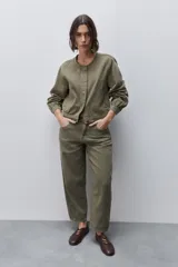 Pantalón jean de tiro alto con calce straight y pierna recta, confeccionado en denim de aspecto limpio. Cuenta con cinco bolsillos, cierre frontal con botón y presillas para cinturón.
