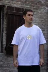 Remera color beige de algodón premium, manga corta y cuello redondo. Presenta un estampado circular en el centro del pecho con un diseño abstracto en tonos grises.