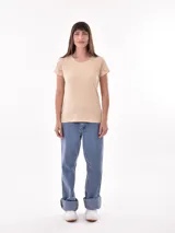 Remera de manga corta color beige claro, con cuello redondo y detalles de bordado tipo ojal (broderie) en las mangas.
