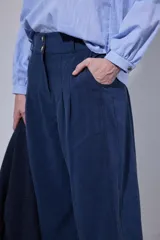 Pantalón tipo bombachita con pinzas que aportan volumen, confeccionado en Tencel. Presenta cierre frontal con botones dorados, bolsillos delanteros y ruedo ajustable mediante botón dorado.