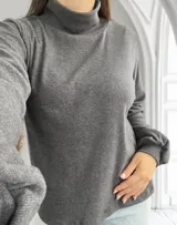 Blusa gris topo de tejido de punto acanalado, con cuello alto y mangas largas abullonadas.