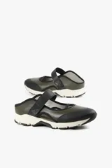 Zapato de diseño urbano color blanco con detalles en negro y amarillo, suela dentada y tira de velcro en el empeine.